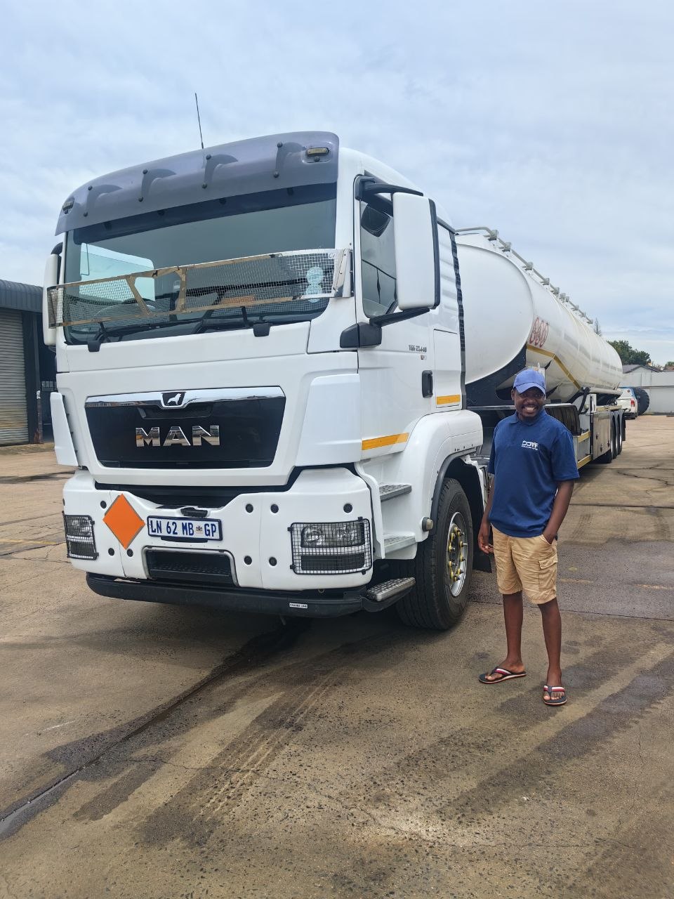 Vurheni Business Group MAN TGS 26.440 truck coupled to a stainless-steel road tanker, Vacopi Logistics crew member beside the cab