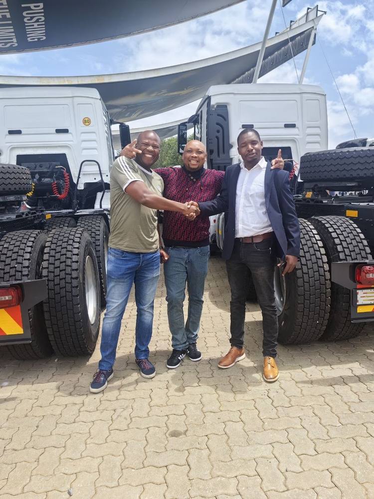 Vongani Boreni and partners at a truck dealership, celebrating a fleet acquisition